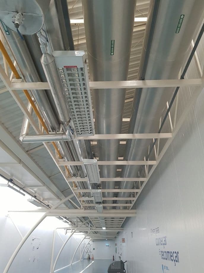 Corredor técnico com tubulações isoladas e leitos de cabos